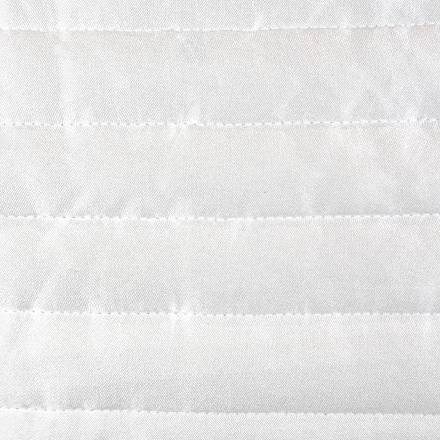 Close-up of white charmeuse fabric with horizontal channel quilting stitching detail.