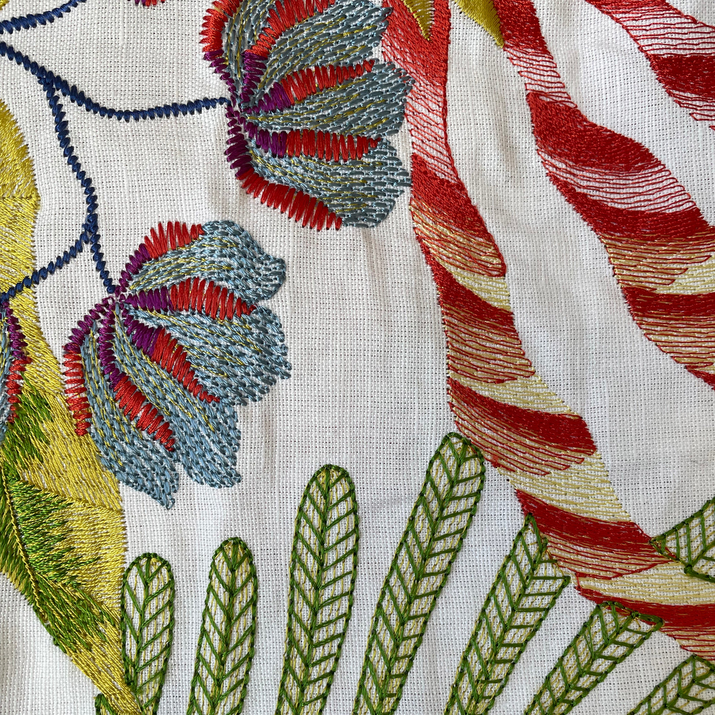 Close-up of Ann Gish Cloud Forest duvet's multicolor botanical embroidery on ivory linen.
