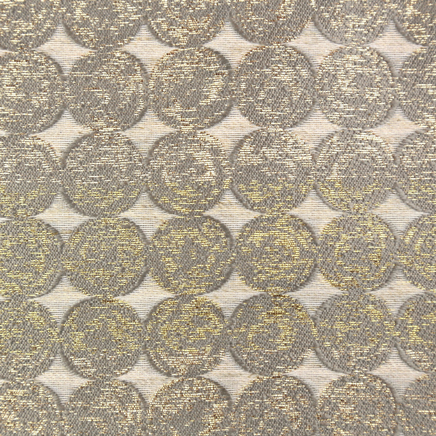 Close-up of Ann Gish Coin curtain panel fabric with woven metallic gold and taupe circle pattern.