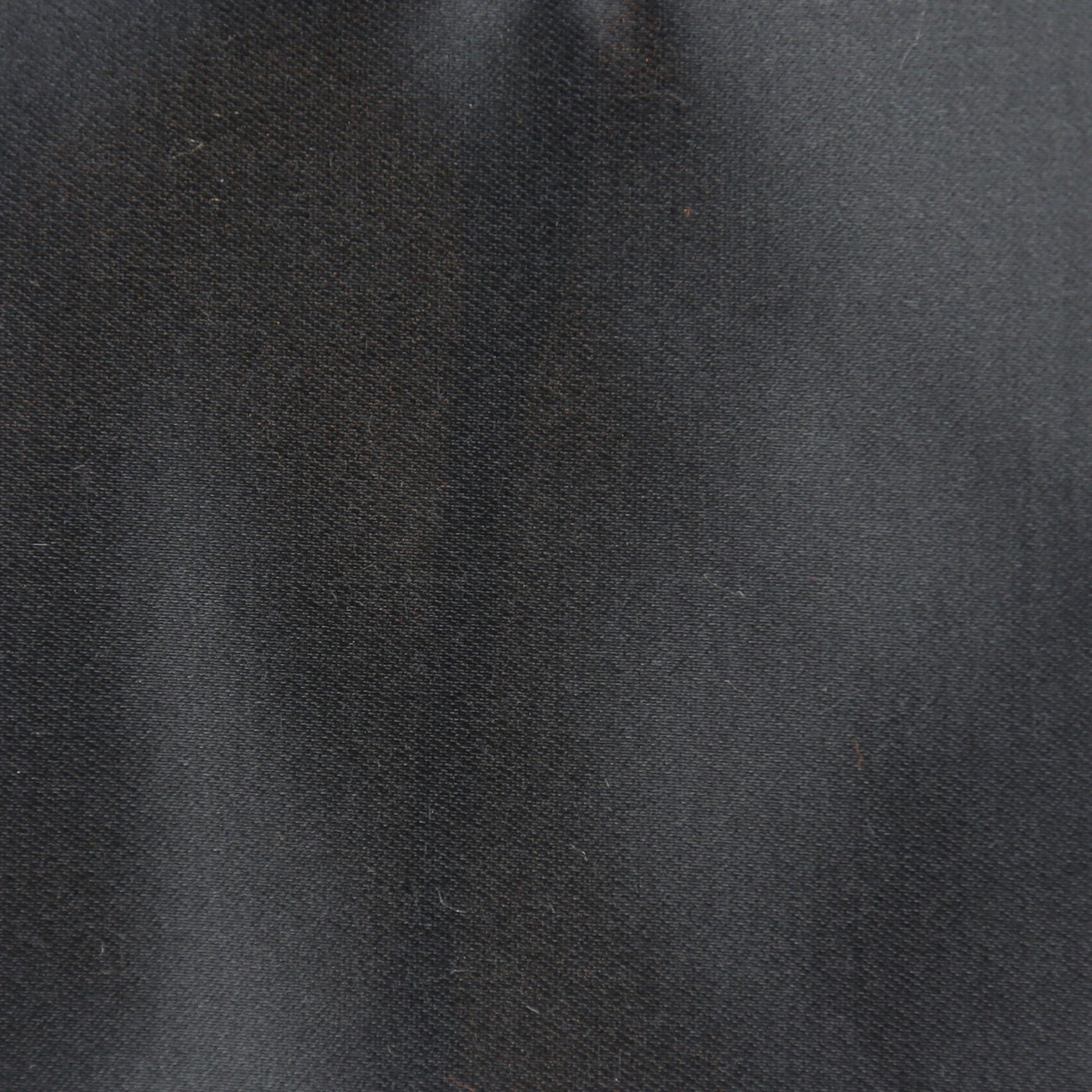 Close-up of charcoal satin fabric with subtle sheen and soft drape.
