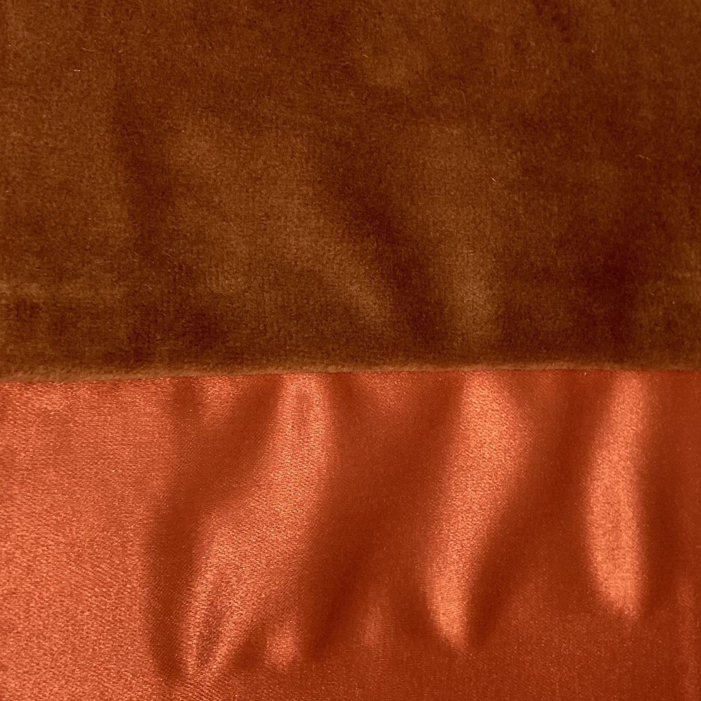 Close-up of burnt orange velvet and satin reverse fabrics on Ann Gish Duchess pillow.