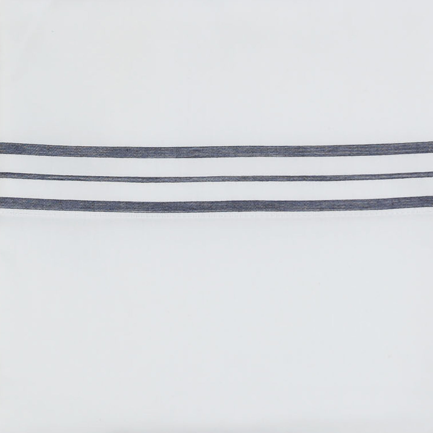 Close-up of three navy embroidered stripes on white Ann Gish pillowcase hem.