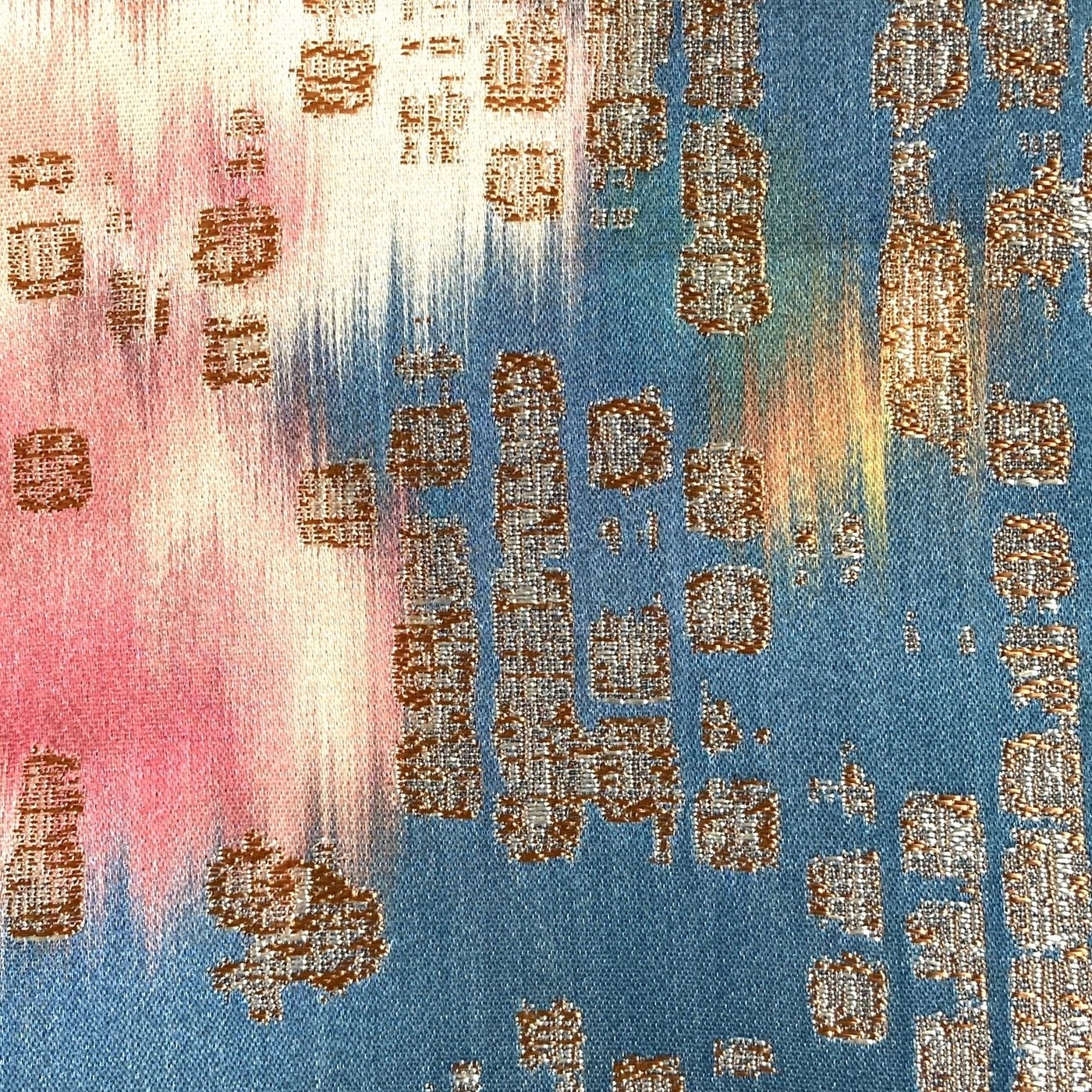 Close-up of Ann Gish Ibiza pillow fabric in pink and teal with gold metallic geometric pattern.