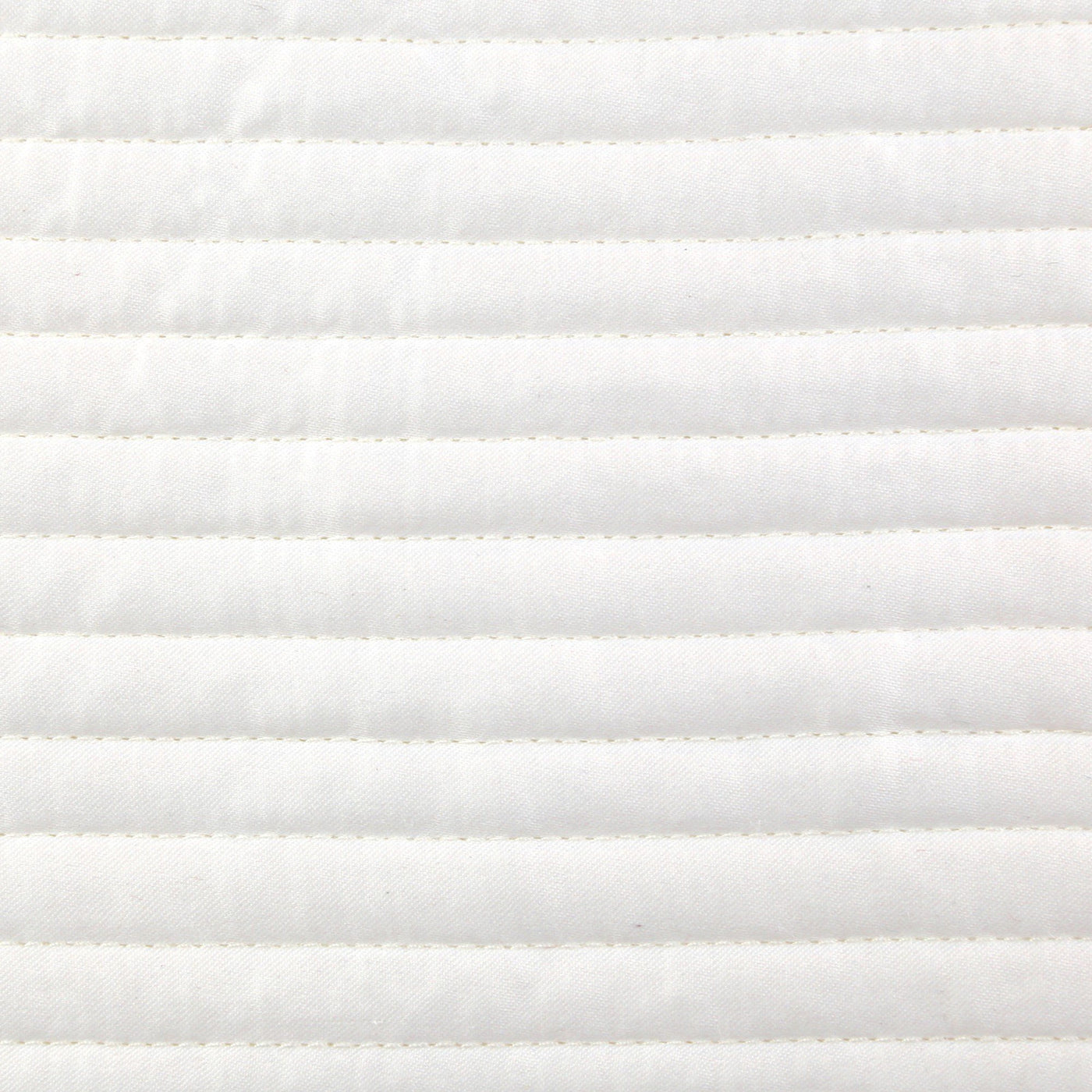 Close-up of ivory quilted coverlet with horizontal channel stitching detail.