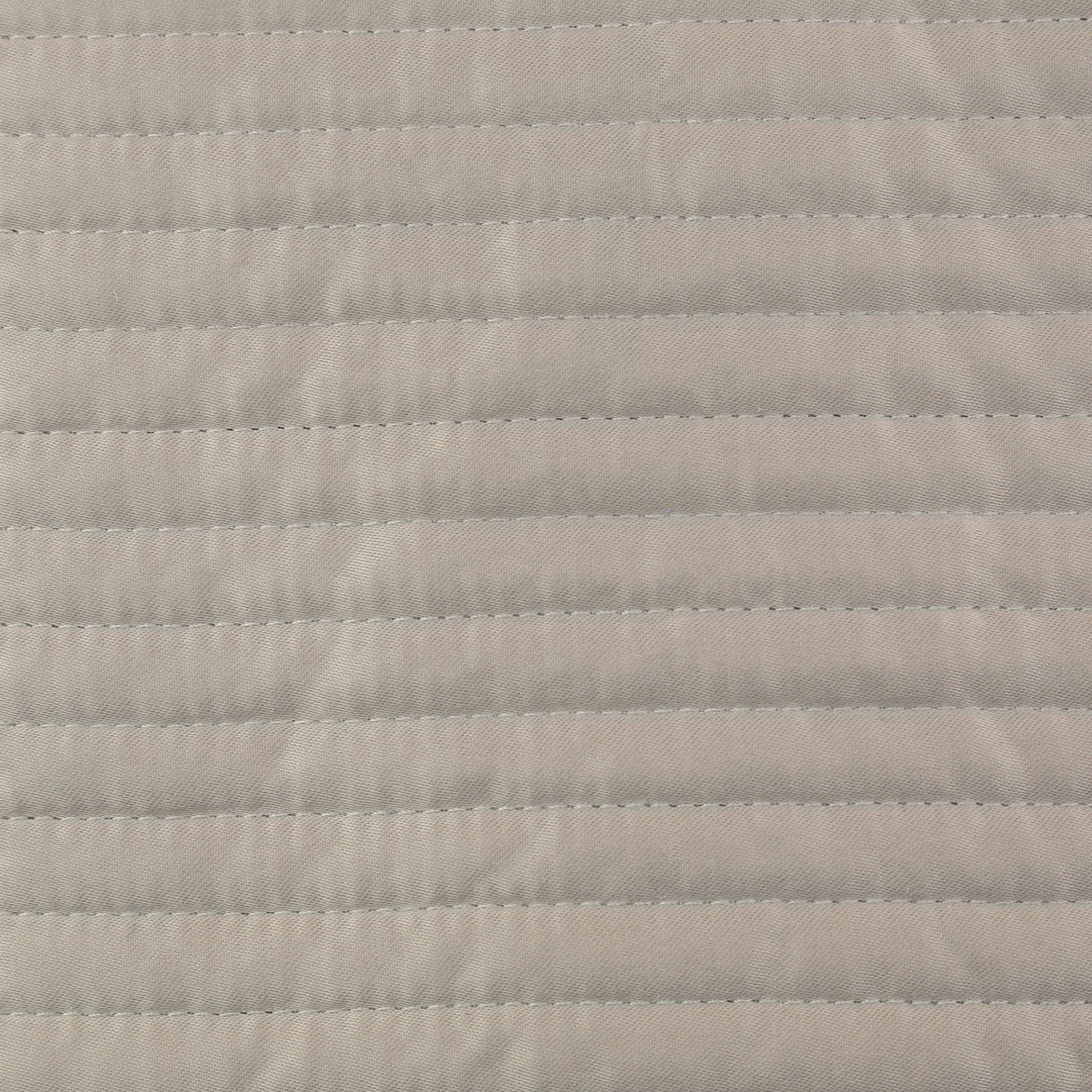 Close-up of Ann Gish Linea coverlet in ivory, showing horizontal quilted stitching detail.