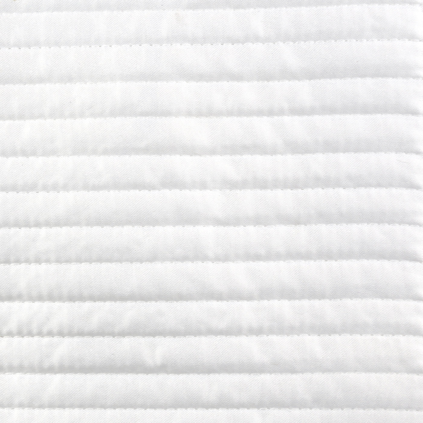 Close-up of Ann Gish Linea coverlet's white horizontal channel quilting detail.