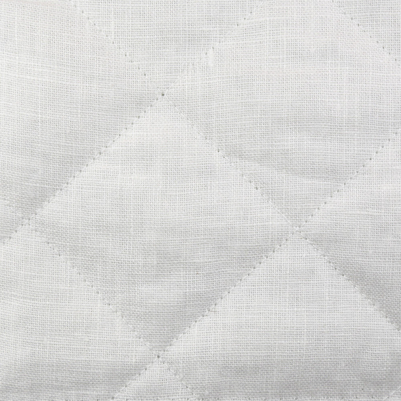 Close-up of Ann Gish Linen Quilted Coverlet showing white diamond quilting and linen weave texture.
