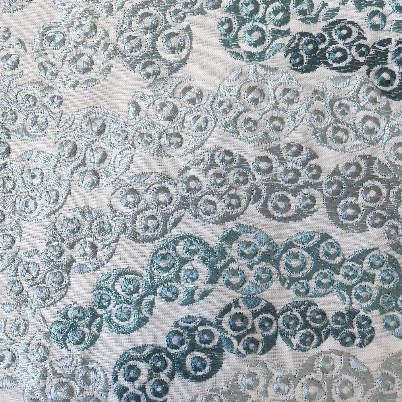 Close-up of Ann Gish Nazar duvet cover showing teal embroidered swirl pattern on ivory fabric.