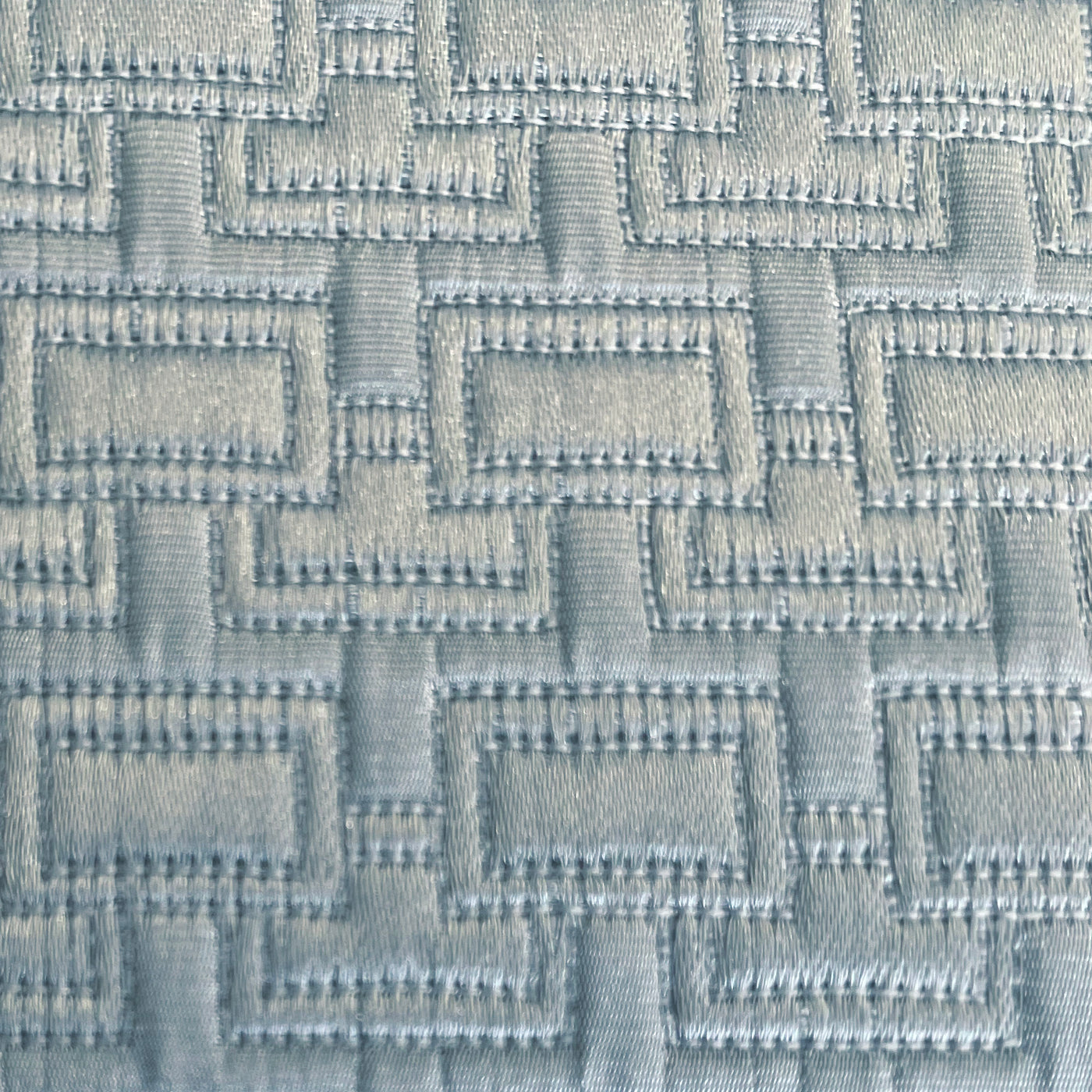 Close-up of pale blue jacquard weave with geometric maze-like pattern on Ann Gish Pavilion pillow.