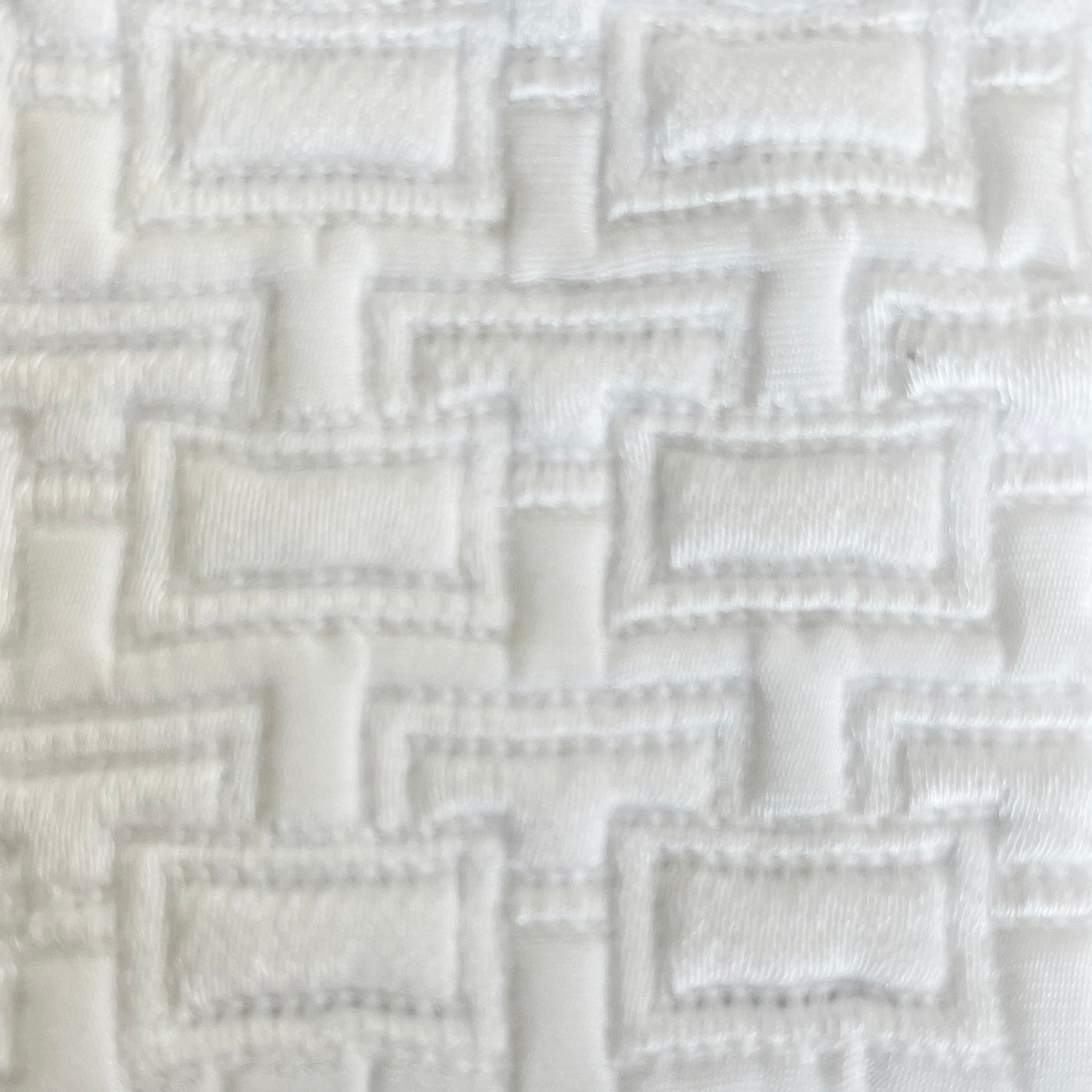 Close-up of Ann Gish Pavilion pillow fabric showing ivory dimensional woven basketweave texture.
