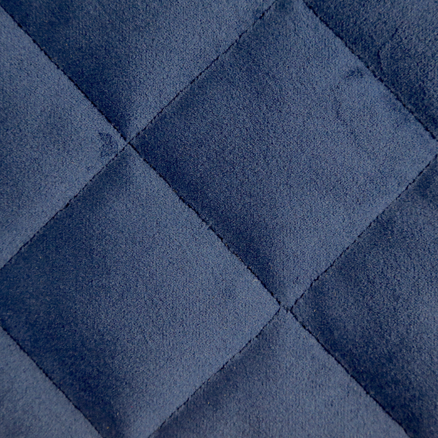 Close-up of navy blue velvet quilted diamond stitching pattern on Ann Gish coverlet.