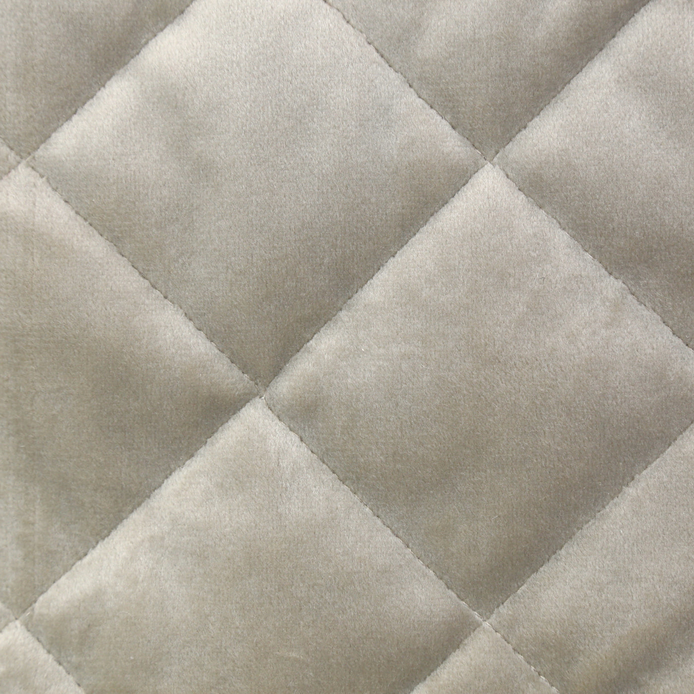 Close-up of Ann Gish Velvet coverlet in ivory, showing diamond quilting pattern on plush fabric.
