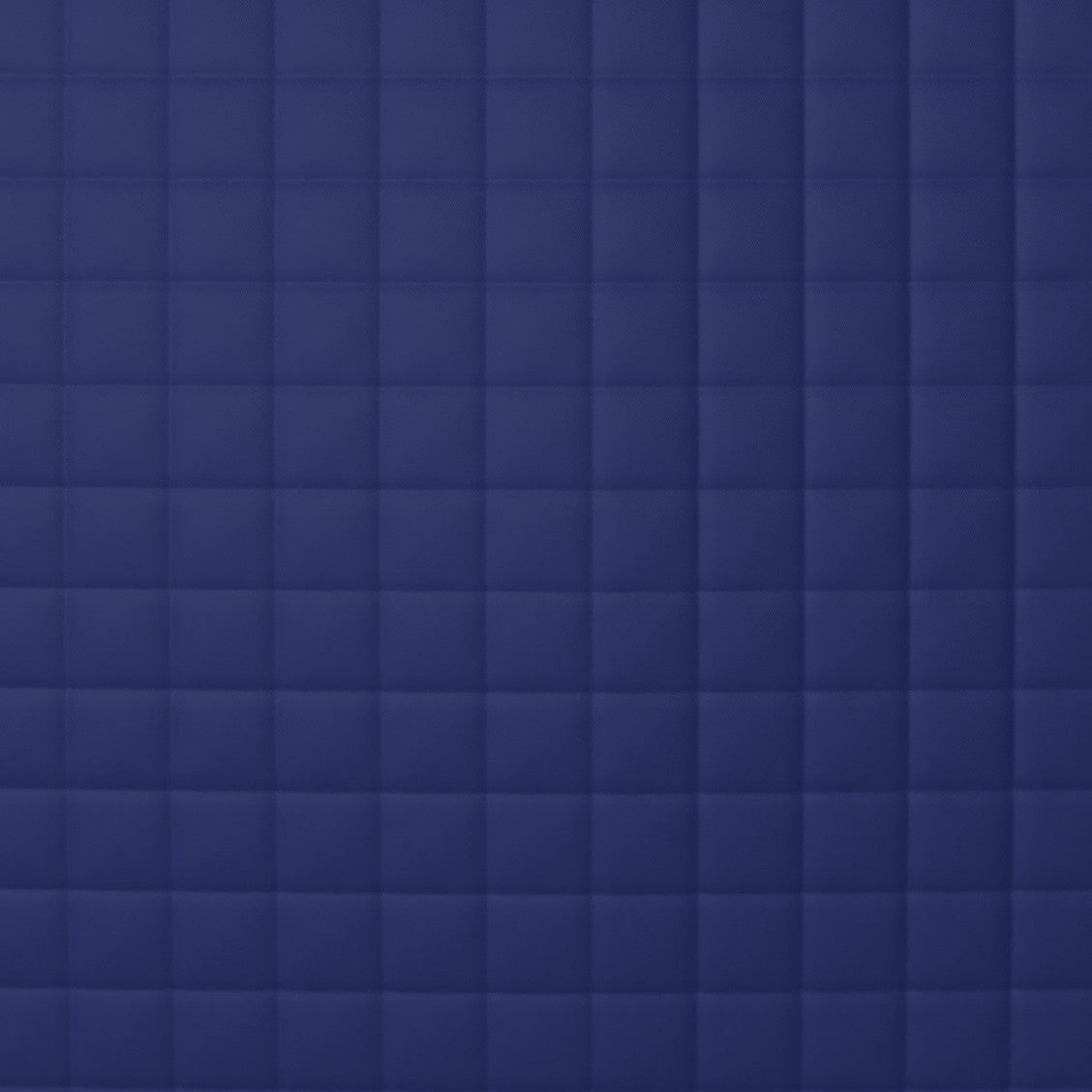 Close-up of Ann Gish navy quilted coverlet showing grid-stitched square pattern.
