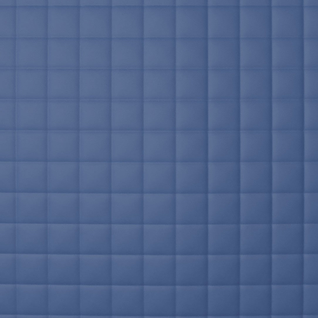 Close-up of Ann Gish Ready-to-Bed 2.0 coverlet showing slate blue square quilting pattern.