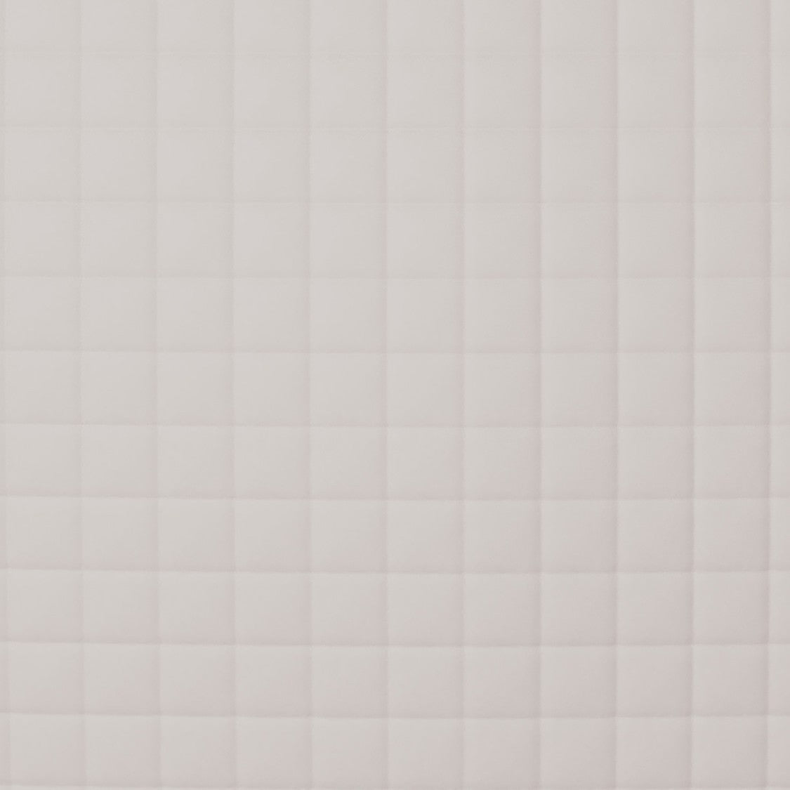 Close-up of Ann Gish Ready-to-Bed 2.0 coverlet showing blush quilted grid stitching pattern.