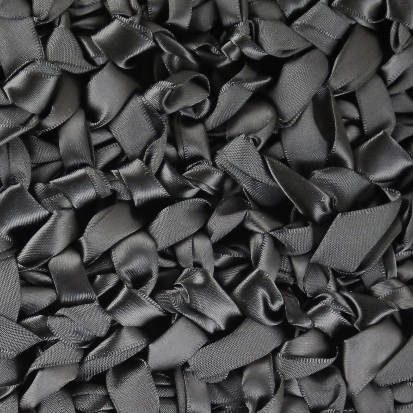 Close-up of Ann Gish Ribbon Knit pillow showing dense charcoal satin ribbon loops.