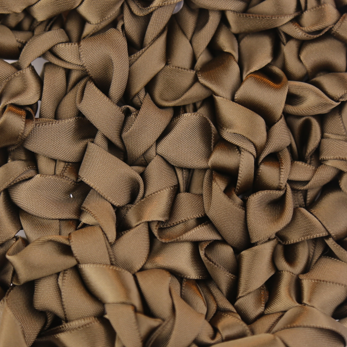 Close-up of Ann Gish Ribbon Knit Pillow showing dense toffee satin ribbon loops across surface.