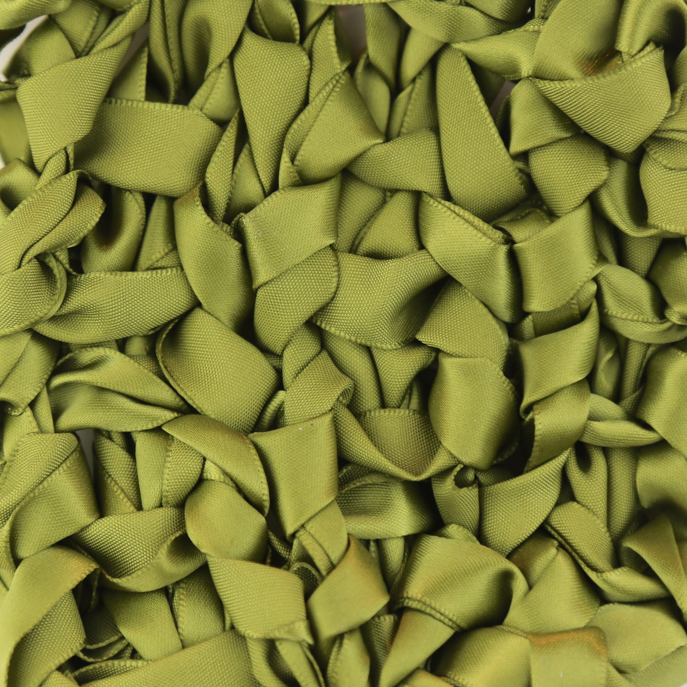 Close-up of olive green ribbon loops stitched onto pillow surface.