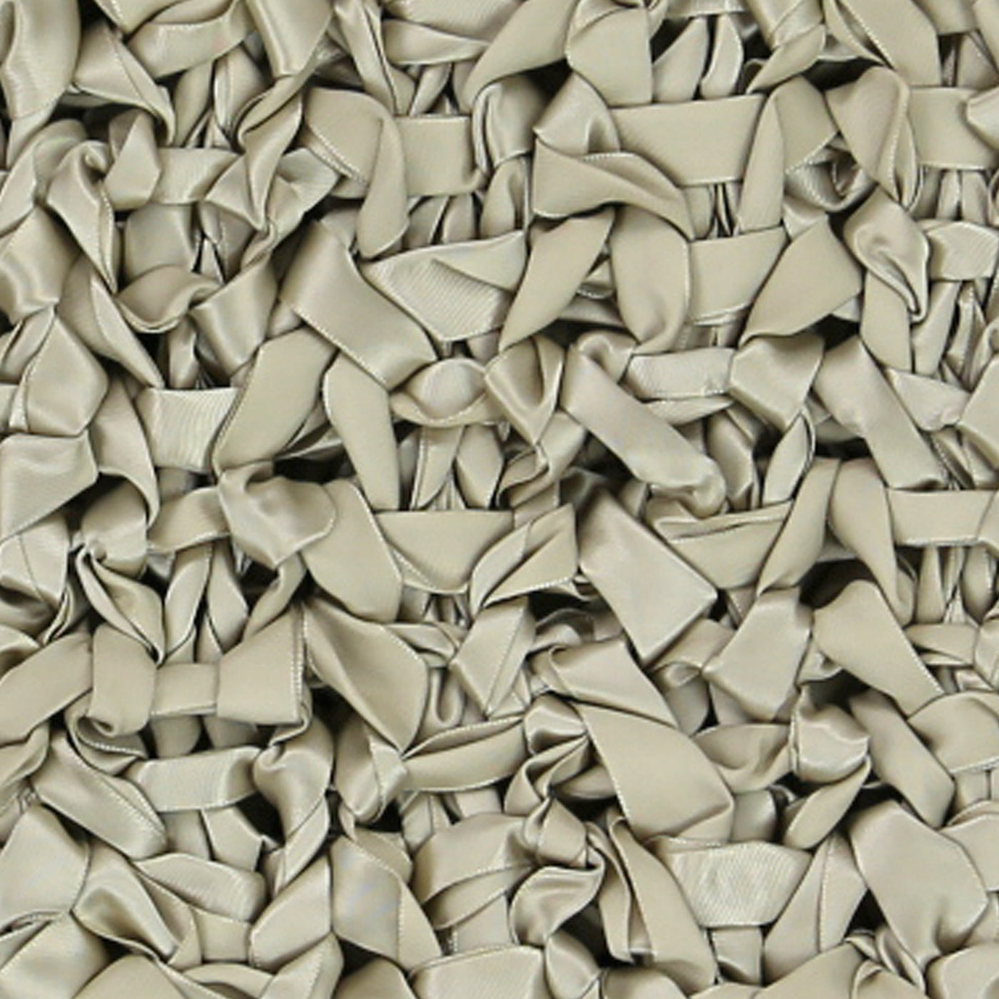 Close-up of Ann Gish Ribbon Knit Pillow surface in taupe, densely layered satin ribbon loops.