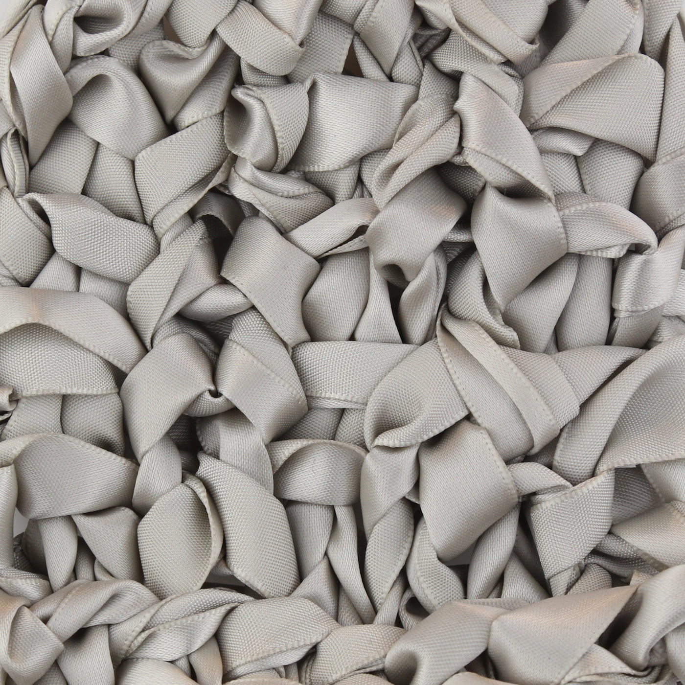 Close-up of Ann Gish Ribbon Knit Pillow in silver-grey looped satin ribbon texture.