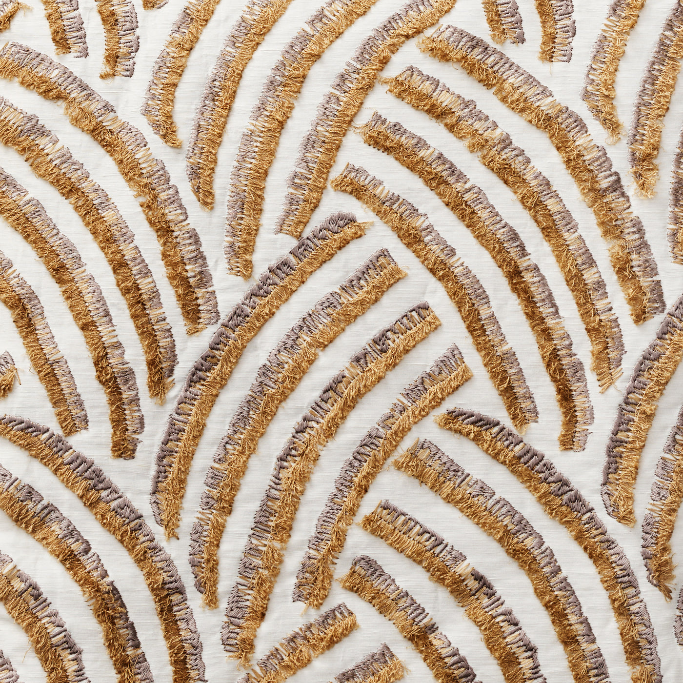 Close-up of Ann Gish Trevi duvet cover showing gold and taupe fringe-trimmed arc embroidery on ivory.