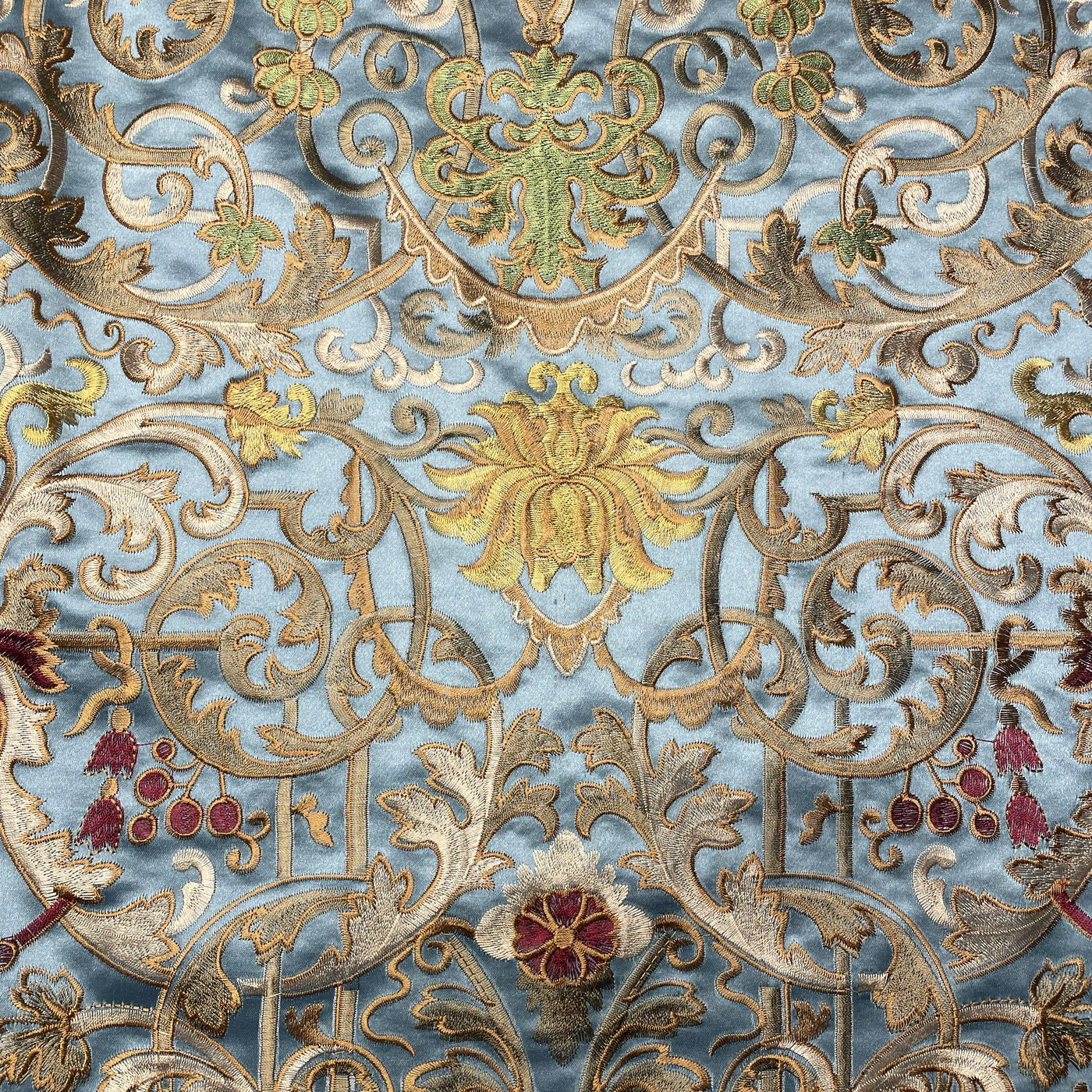 Close-up of Ann Gish Venezia duvet cover showing gold and multicolor floral embroidery on powder blue fabric.