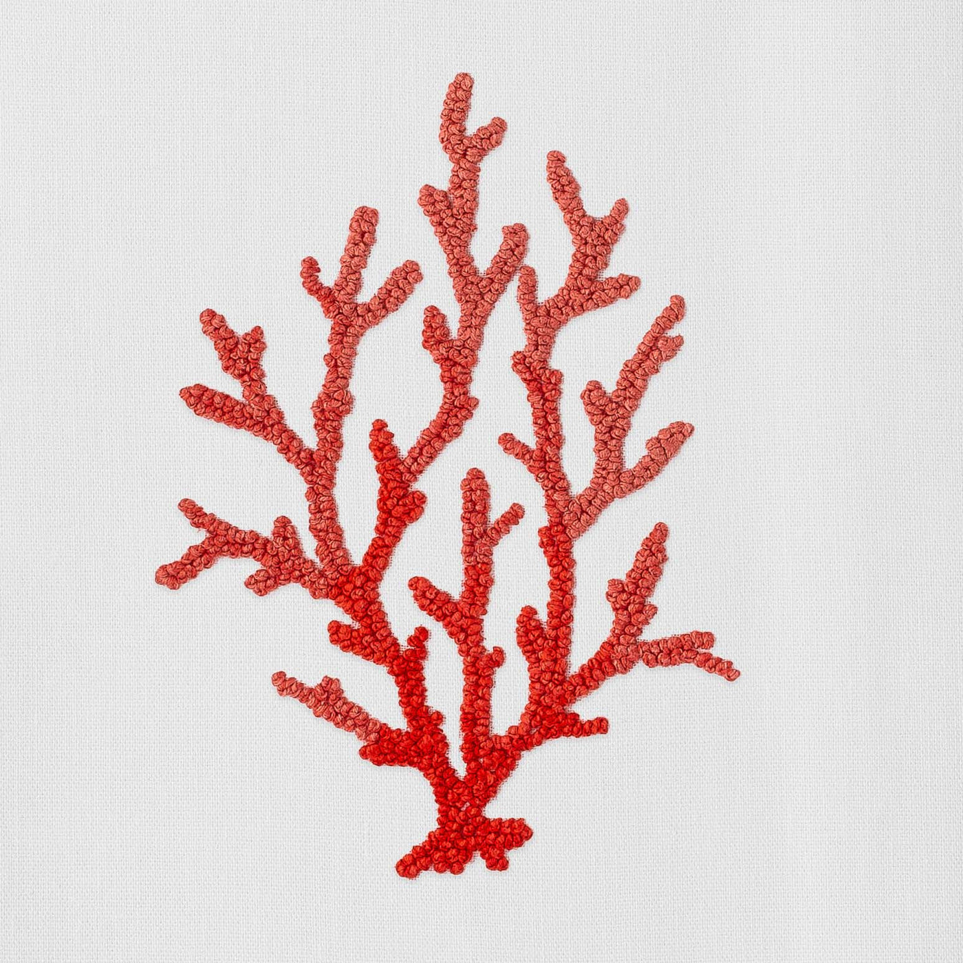 Henry Handwork red coral branch embroidery close-up on white linen napkin.
