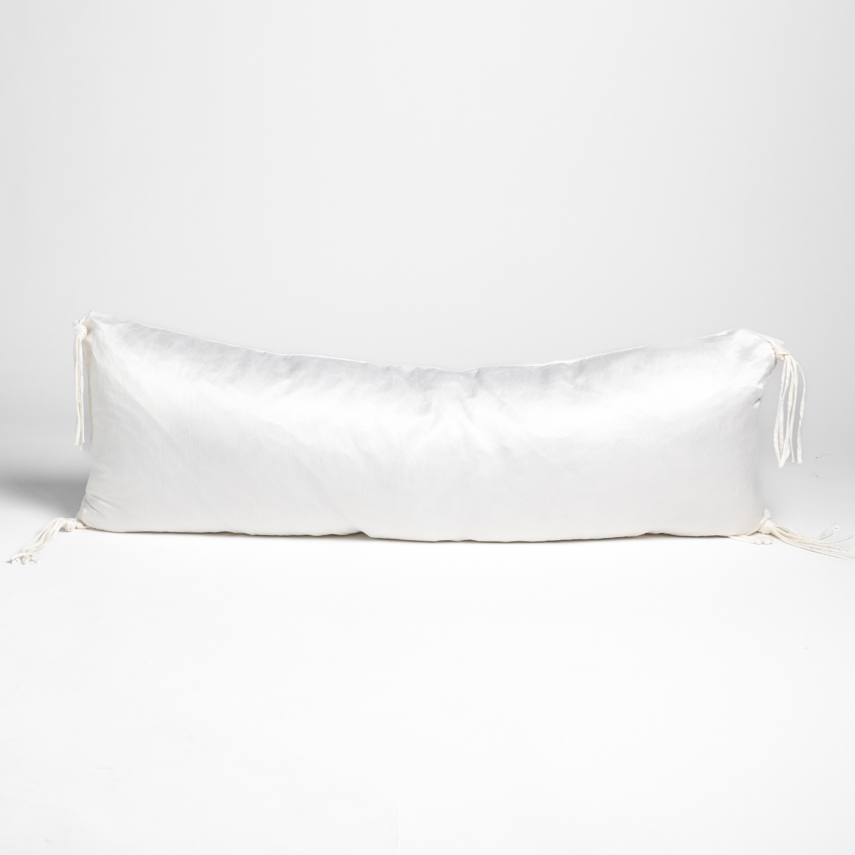Bella Notte Taline throw pillow in White, long bolster shape with tassel ties at ends.