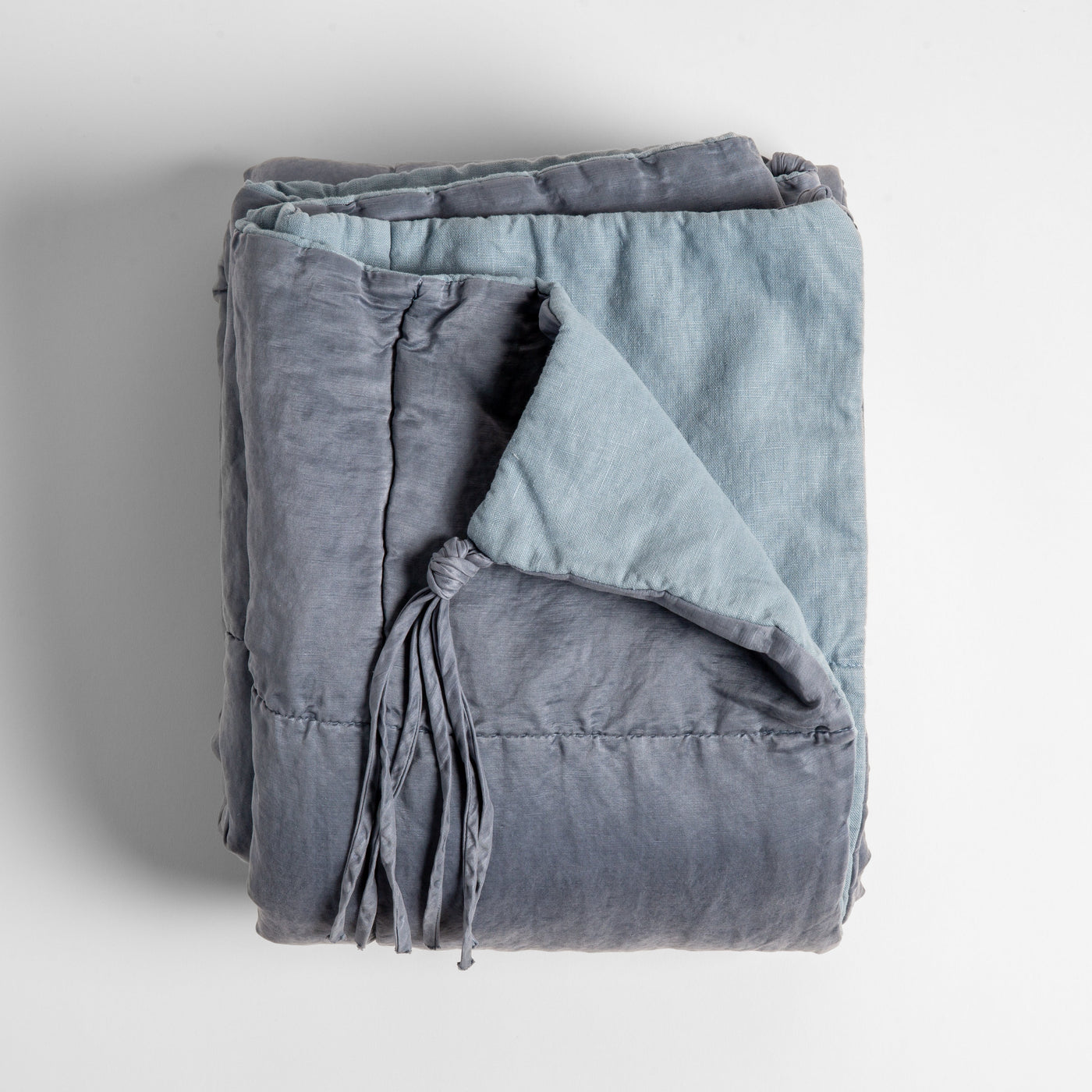 Bella Notte Taline blanket in Tahoe Blue, folded to show tassel trim and contrast lining.