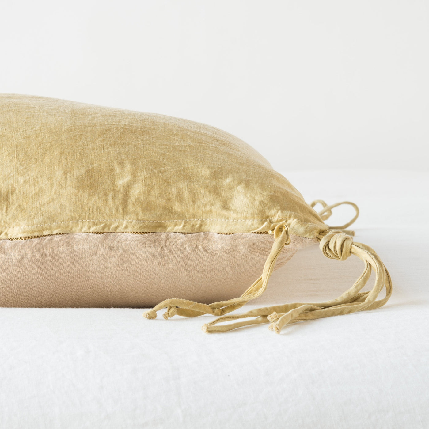 Side view of Honeycomb Taline throw pillow showing tassel tie closure detail and seam.