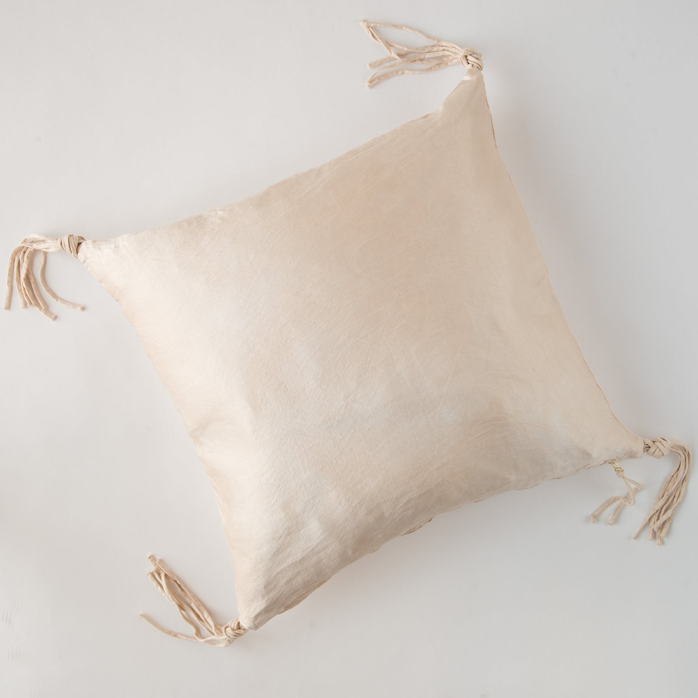 Pearl Taline throw pillow overhead view, knotted corner tassels on linen fabric.