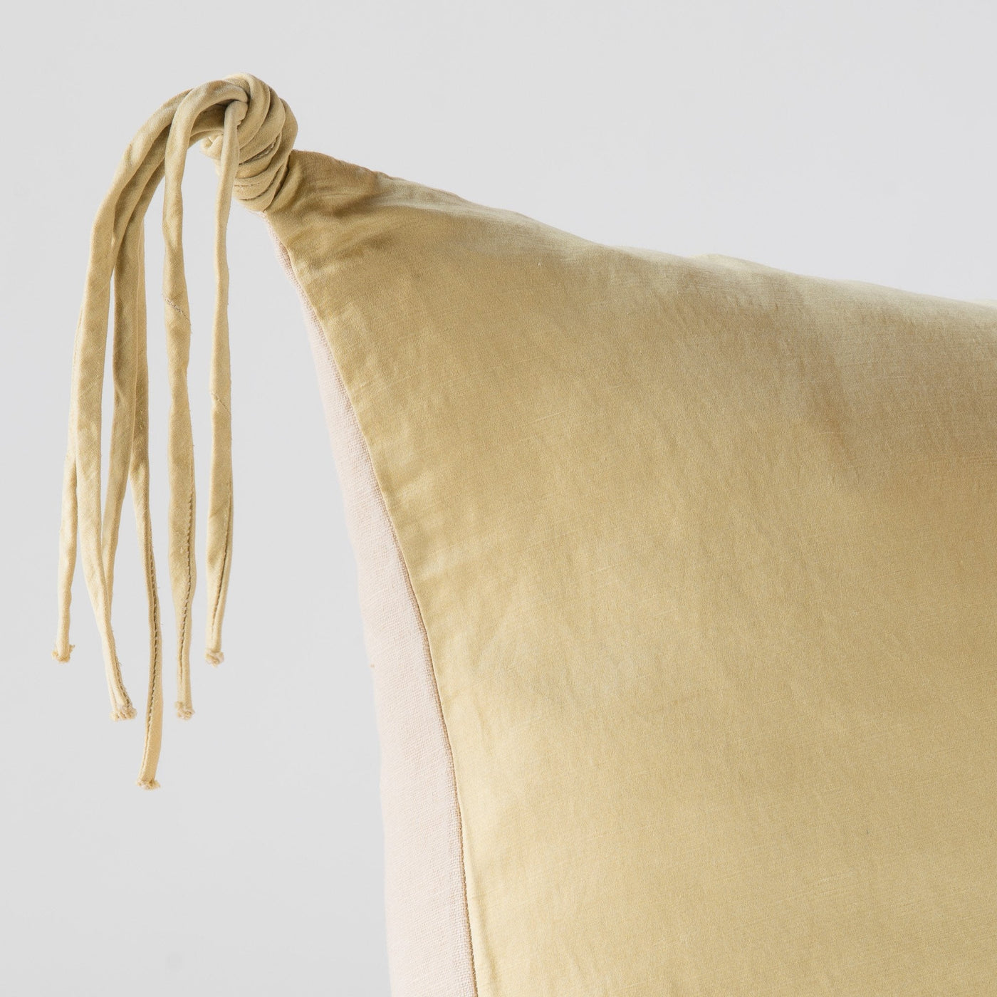 Close-up of Honeycomb Bella Notte Taline sham corner showing knotted tassel trim detail.