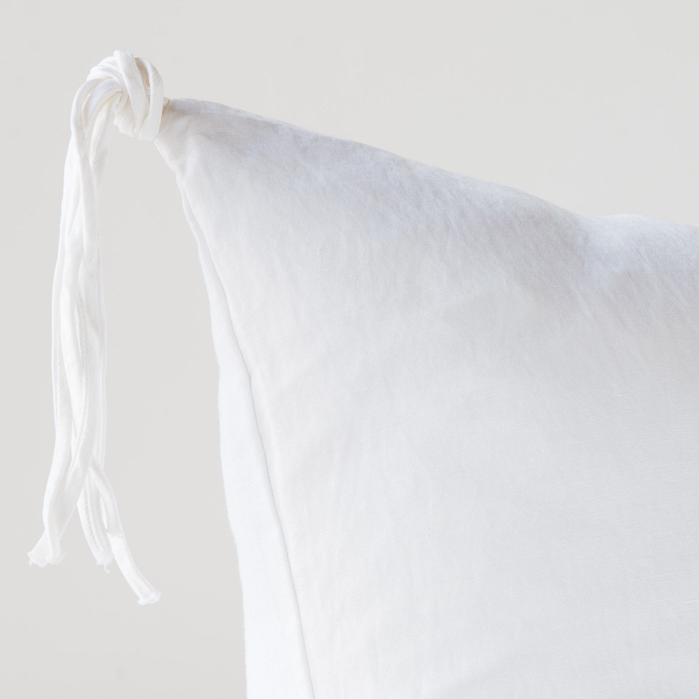 Close-up of White Bella Notte Taline sham corner with knotted tassel tie detail.