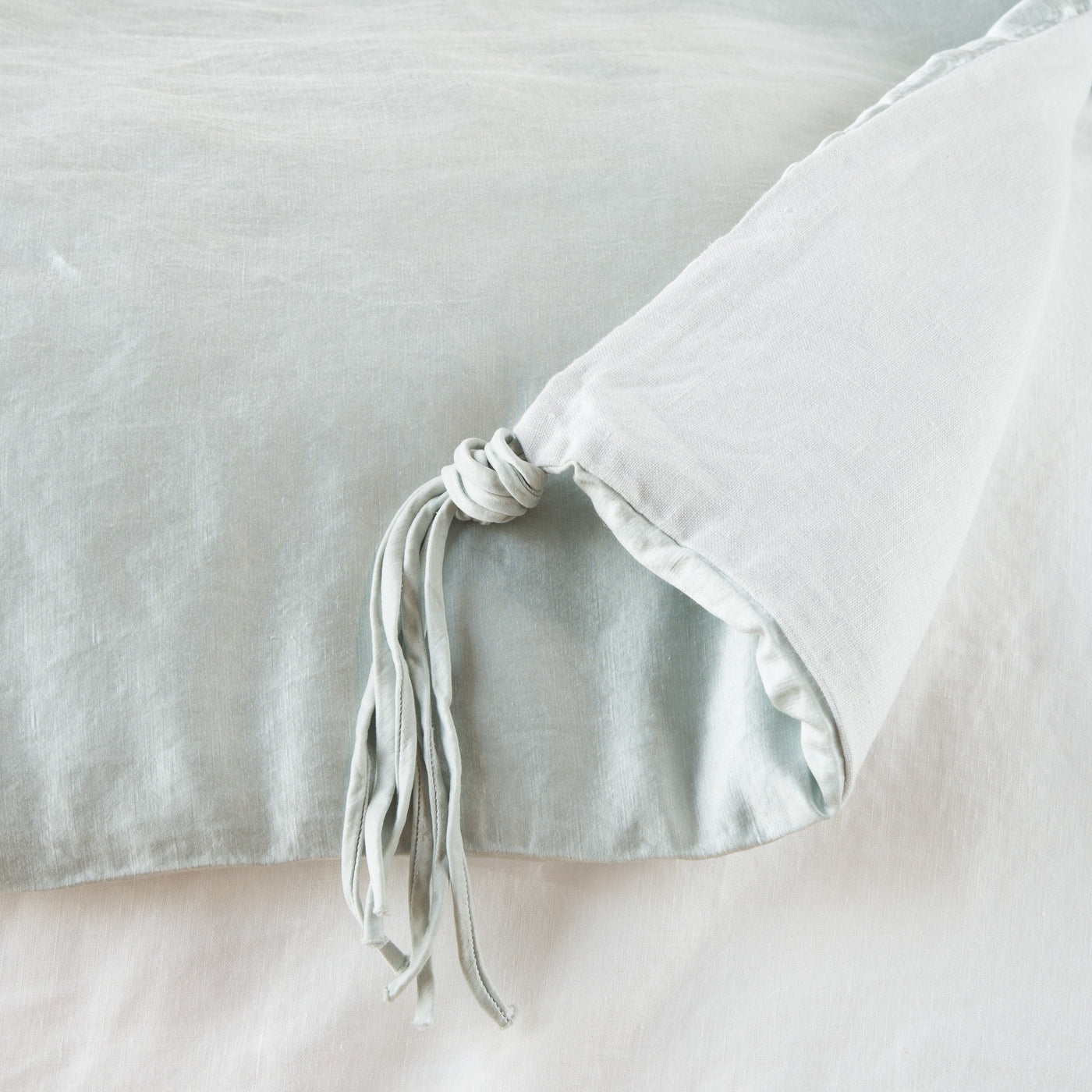 Close-up of Bella Notte Taline blanket corner in Cloud, showing knotted linen tie detail.