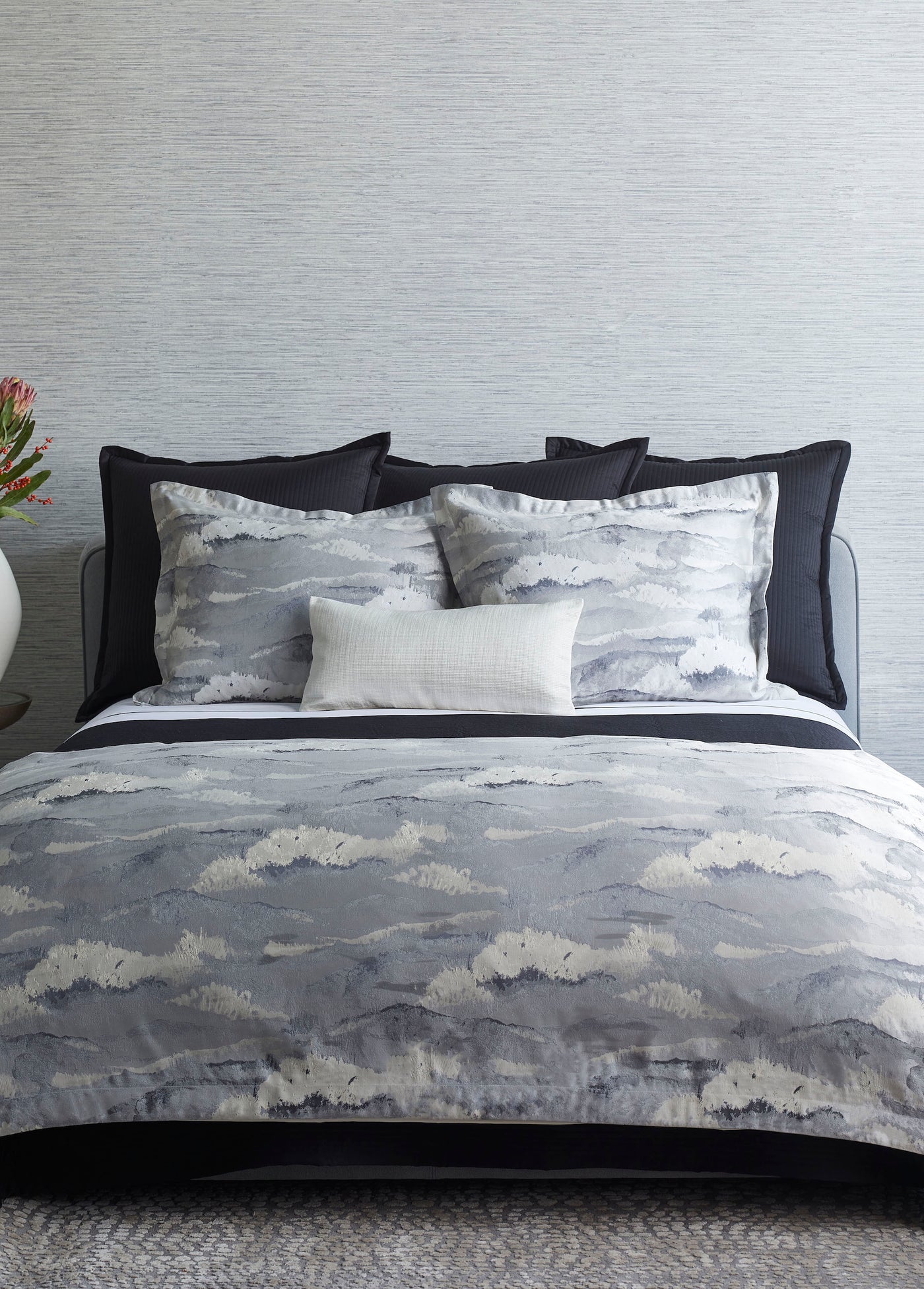 Ann Gish Tempest duvet set styled on bed, grey watercolor cloud print with navy border.
