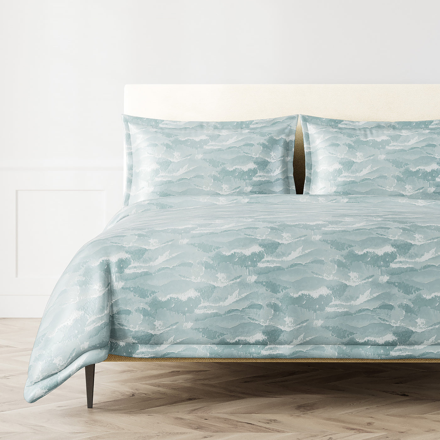 Ann Gish Tempest duvet set in seafoam blue with wave-print pattern, styled on a bed.