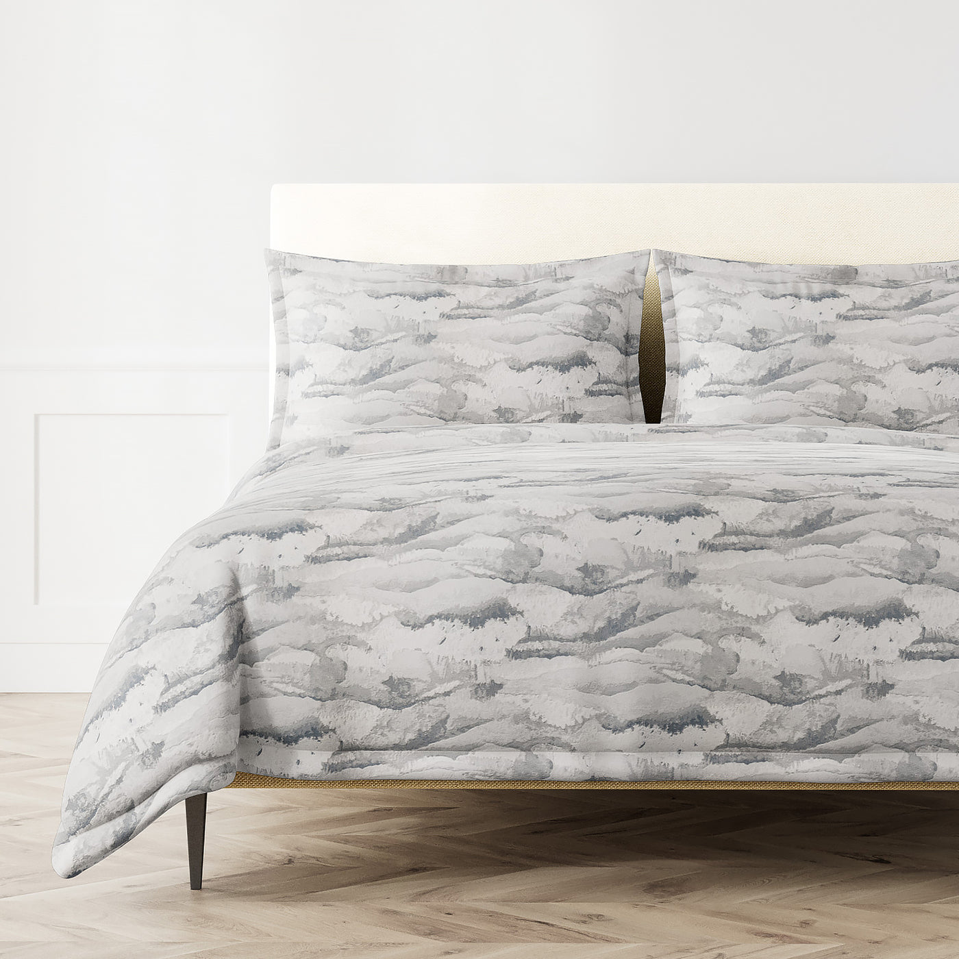 Tempest duvet set styled on bed, grey watercolor brushstroke pattern across duvet and shams.