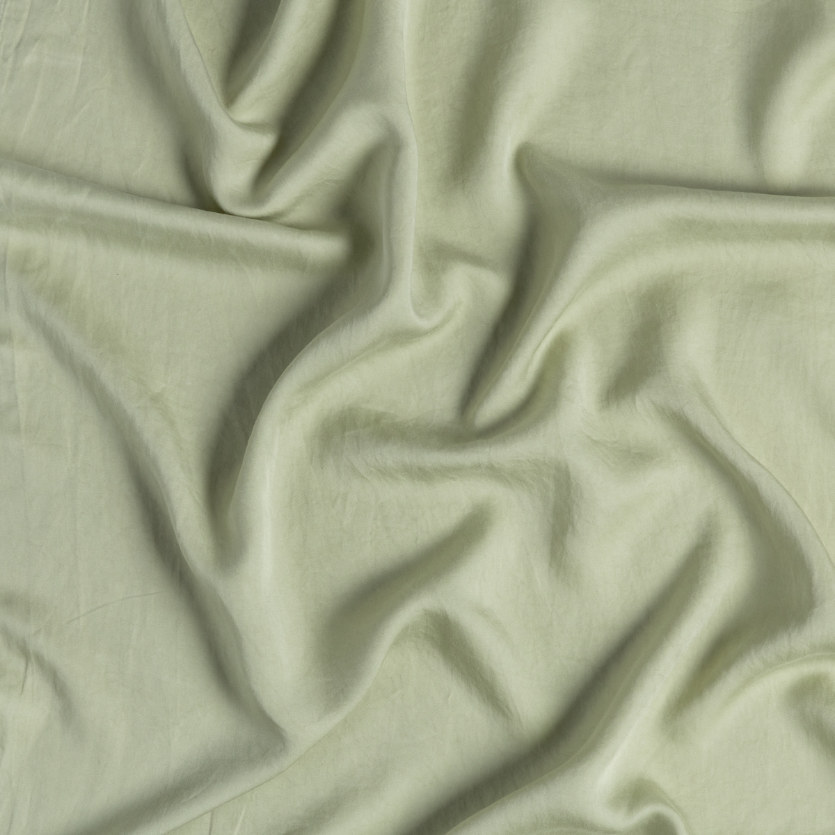 Soft folds of Desert Sage Madera Luxe fabric showing smooth drape and sheen.