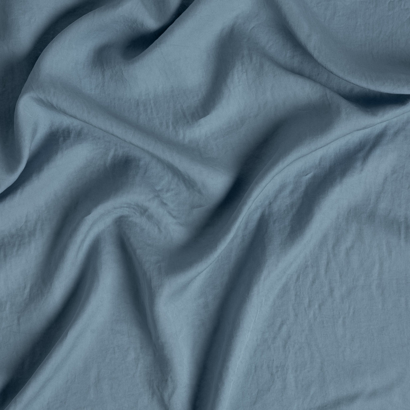 Close-up of Bella Notte Madera Luxe flat sheet in Tahoe Blue, showing soft fabric drape.