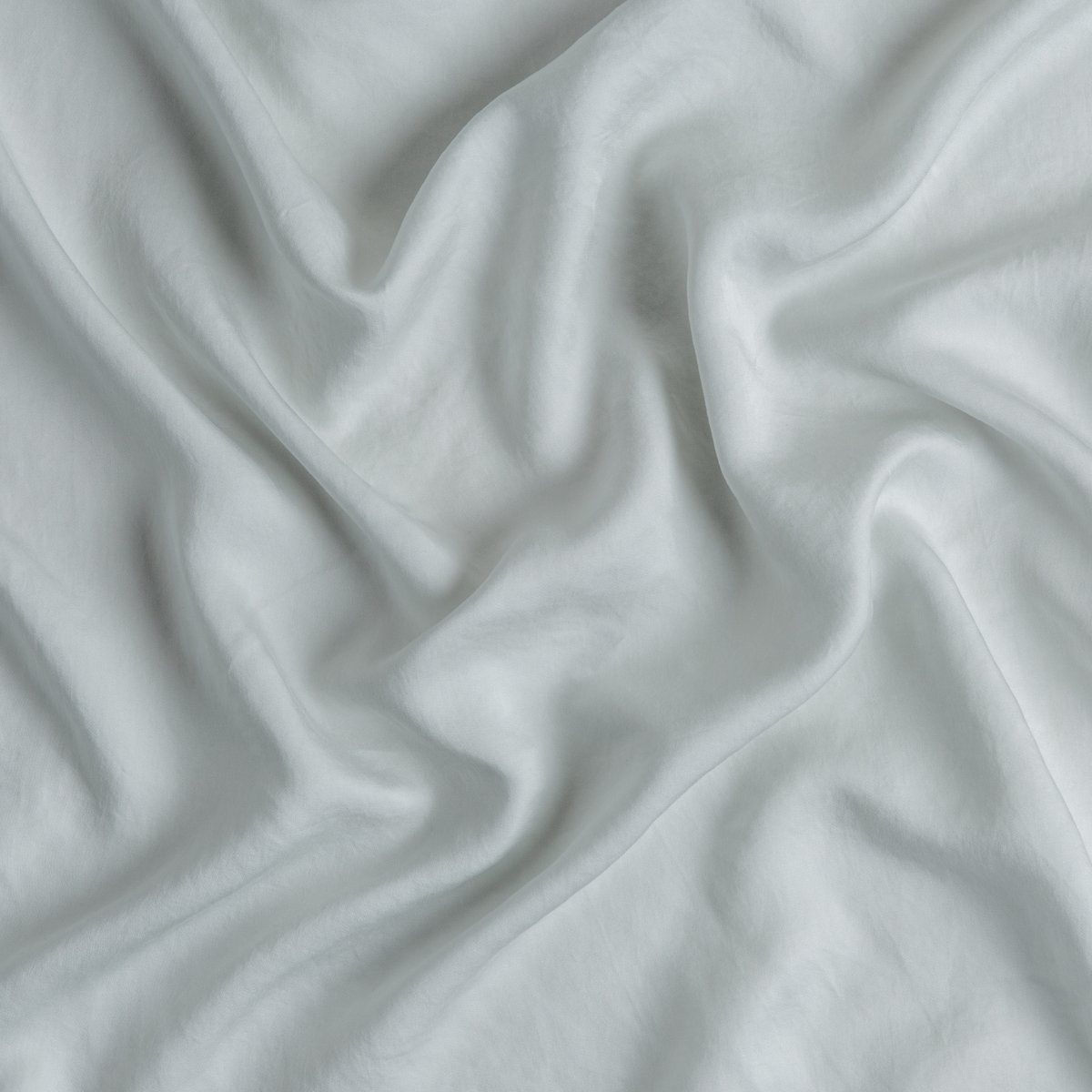 Close-up of Bella Notte Madera Luxe flat sheet in Cloud, showing soft fabric drape and sheen.
