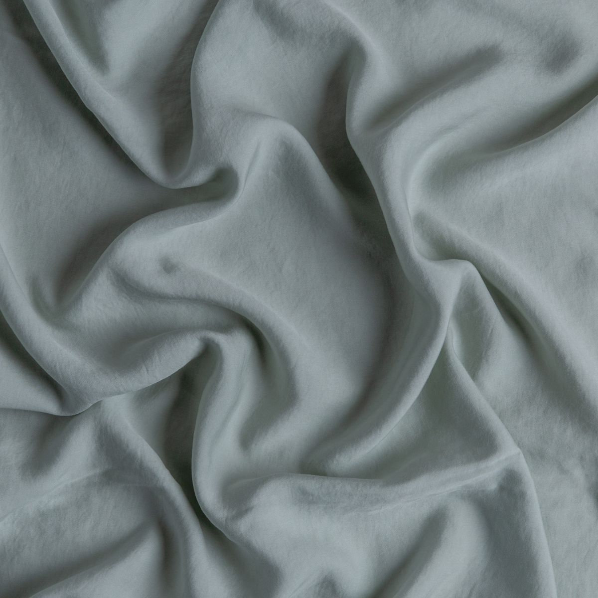 Soft draping folds of Eucalyptus Madera Luxe fabric, showing smooth texture and subtle sheen.