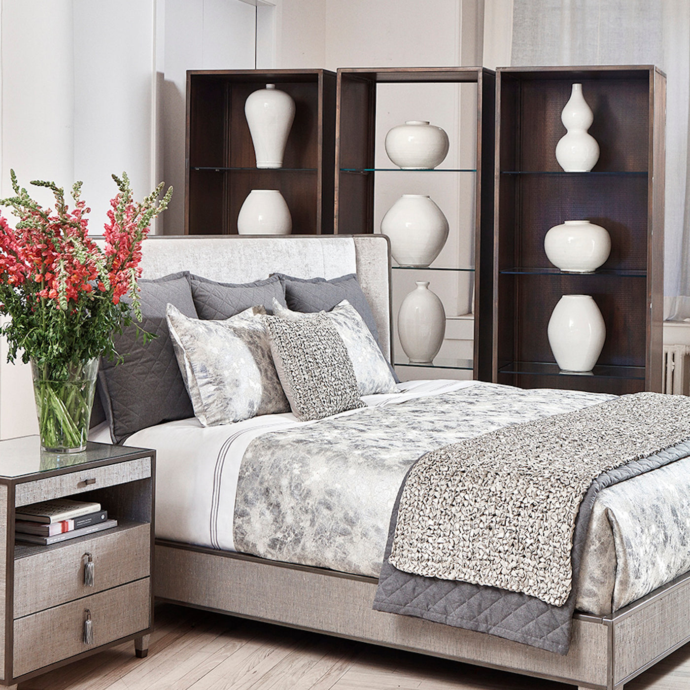 Ann Gish Terrazzo duvet set styled on bed with floral throw and grey quilted blanket in neutral bedroom.