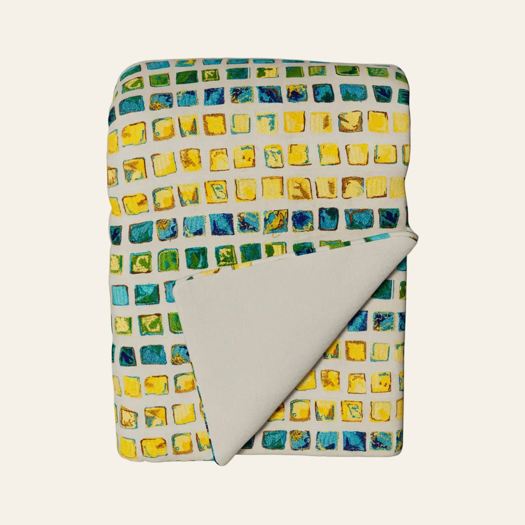 Folded fabric with colorful square pattern on a white background