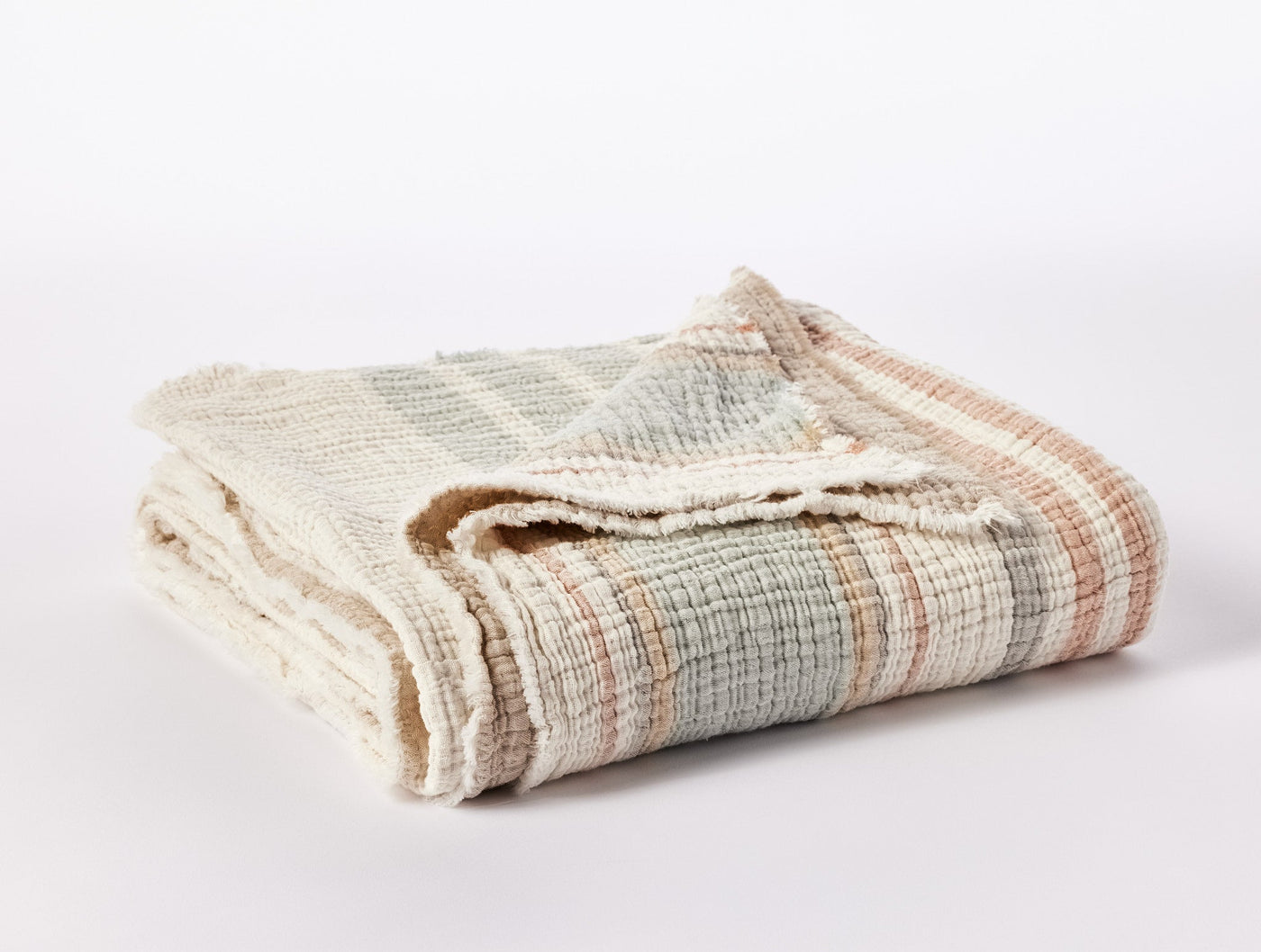 Coyuchi Topanga Matelassé throw folded, ivory with sage and terracotta plaid weave.