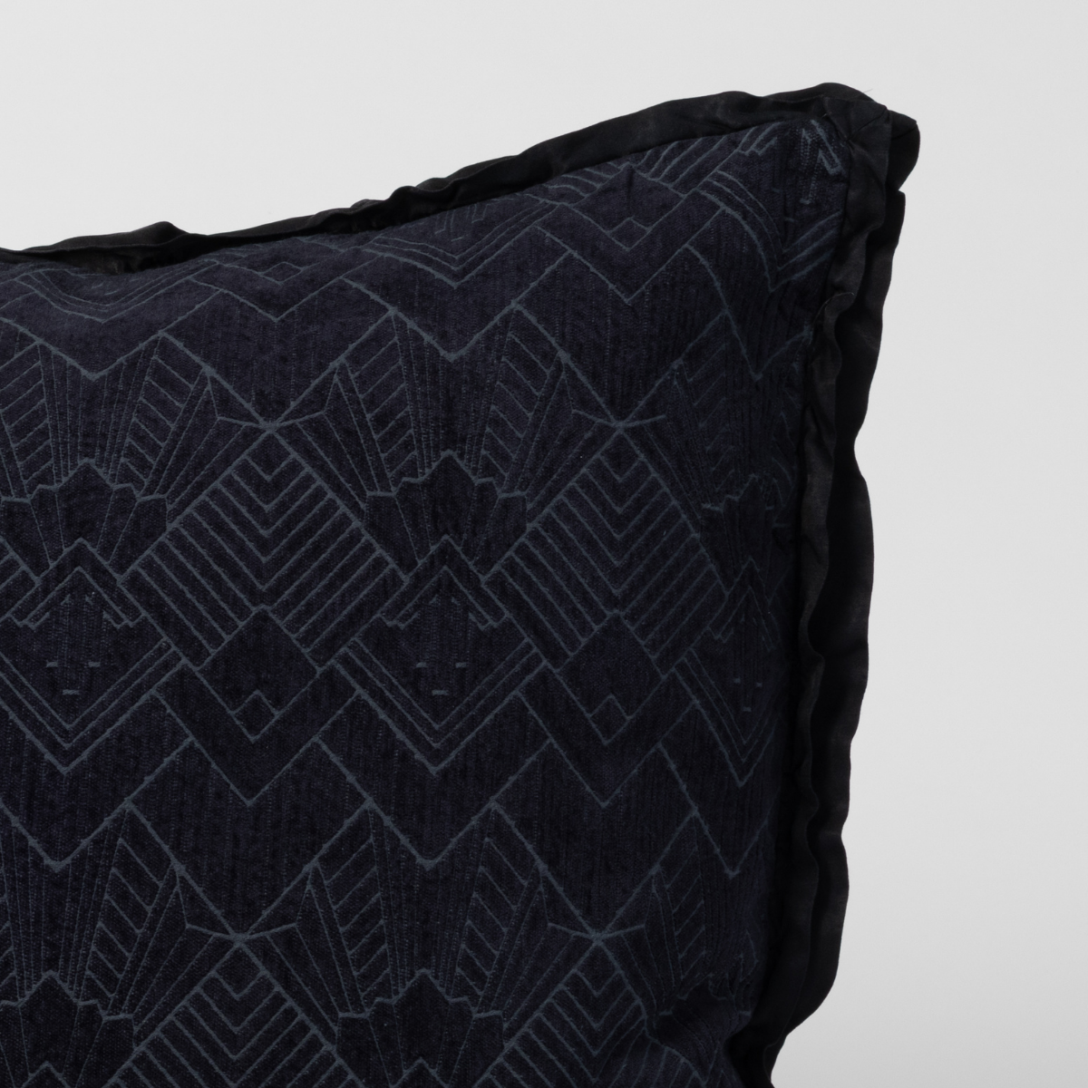 Close-up of Slate Bella Notte Trettino sham corner showing geometric embroidery and flanged edge.