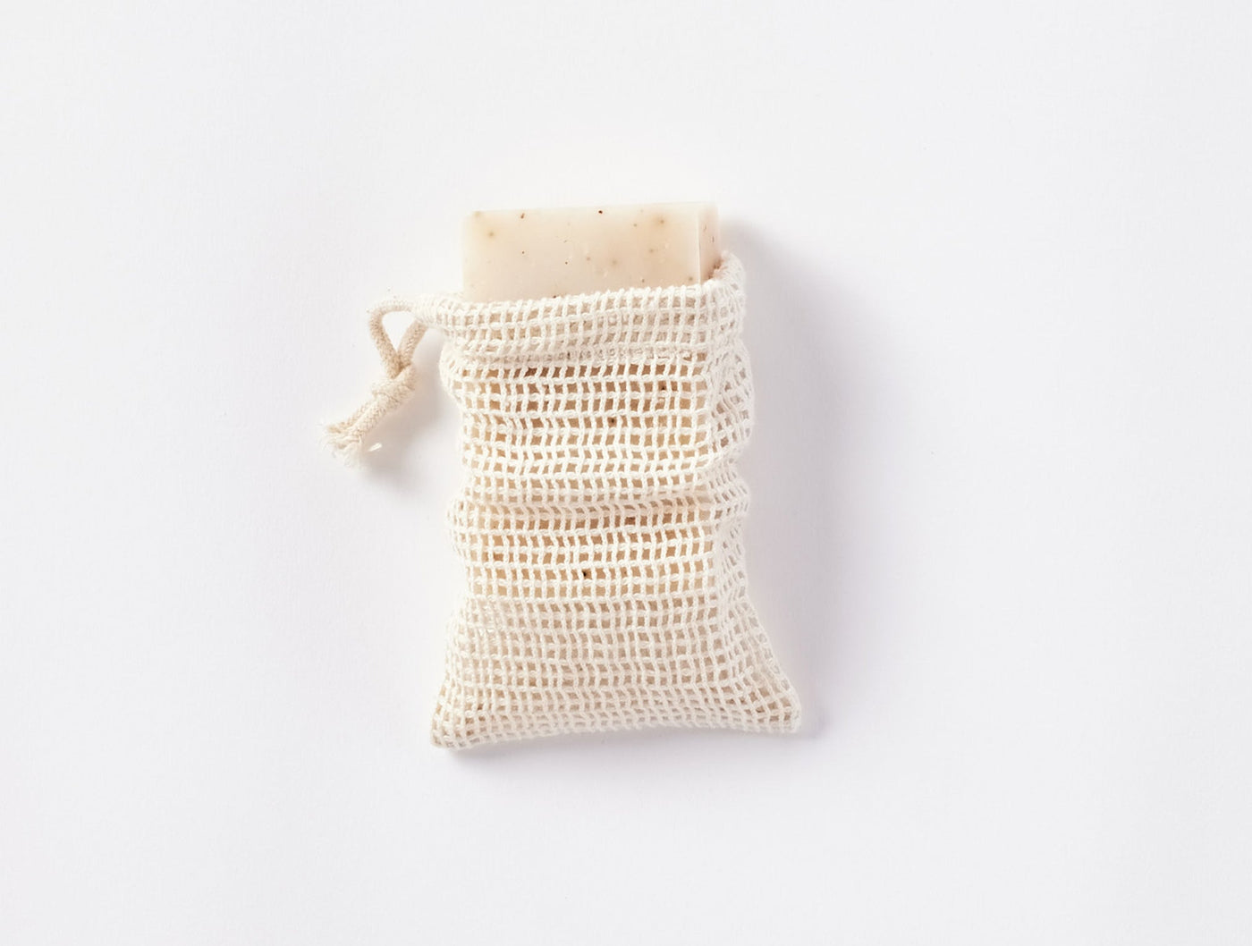 Coyuchi Bare soap bag in natural cotton mesh with drawstring closure.