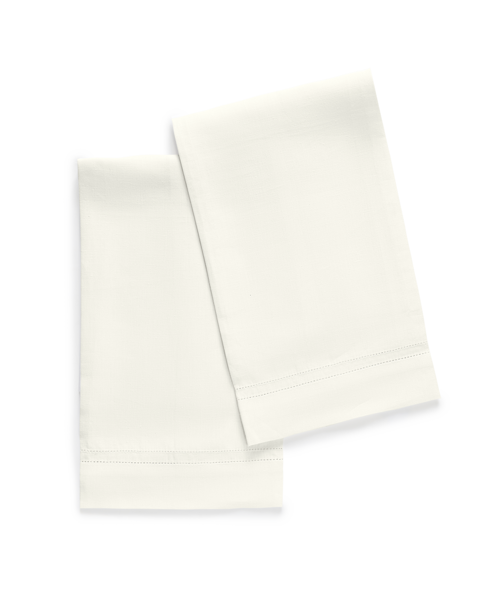 The Matouk Valentina Hemstitch Guest Towels, shown folded on a light background, feature elegant hemstitch borders—ideal for adding a touch of luxury to any tabletop collection.