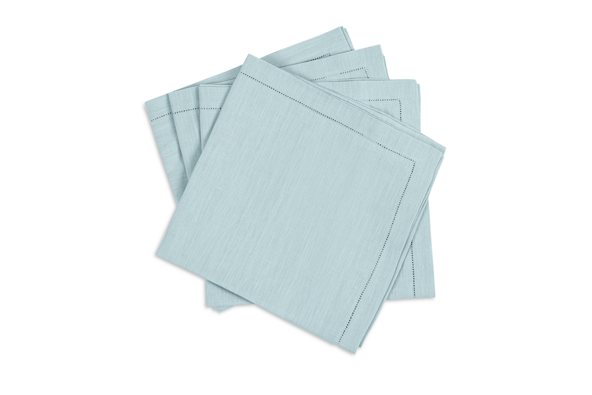 The Valentina Hemstitch Napkin Set by Matouk features four light blue linen napkins with delicate hemstitch borders, neatly stacked on a white background.