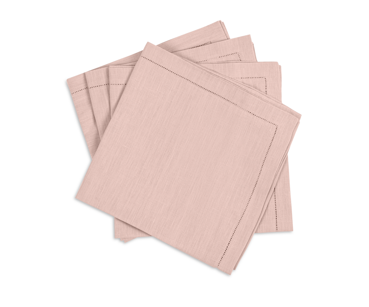 The Valentina Hemstitch Napkin Set by Matouk includes four folded pale pink napkins with delicate hemstitch borders, neatly stacked on a white background.