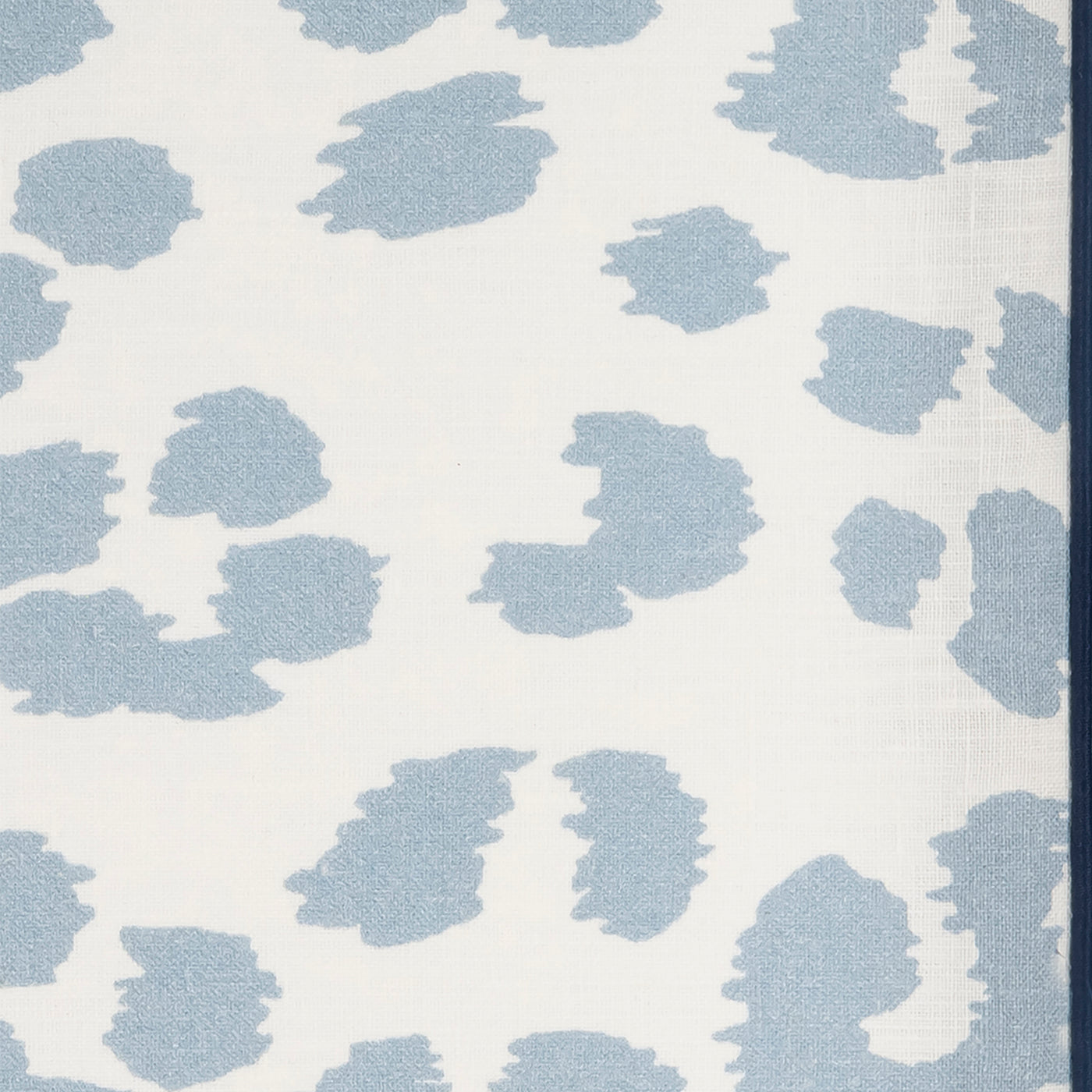 Close-up of Matouk Valentina linen weave in powder blue abstract spot pattern on ivory.